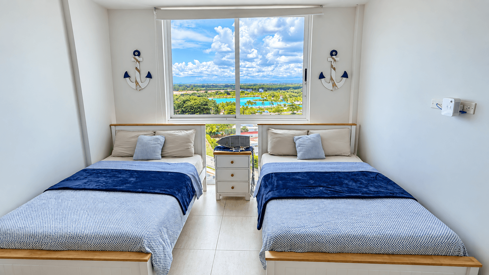 Segunda recámara con dos camas individuales y decoración marina