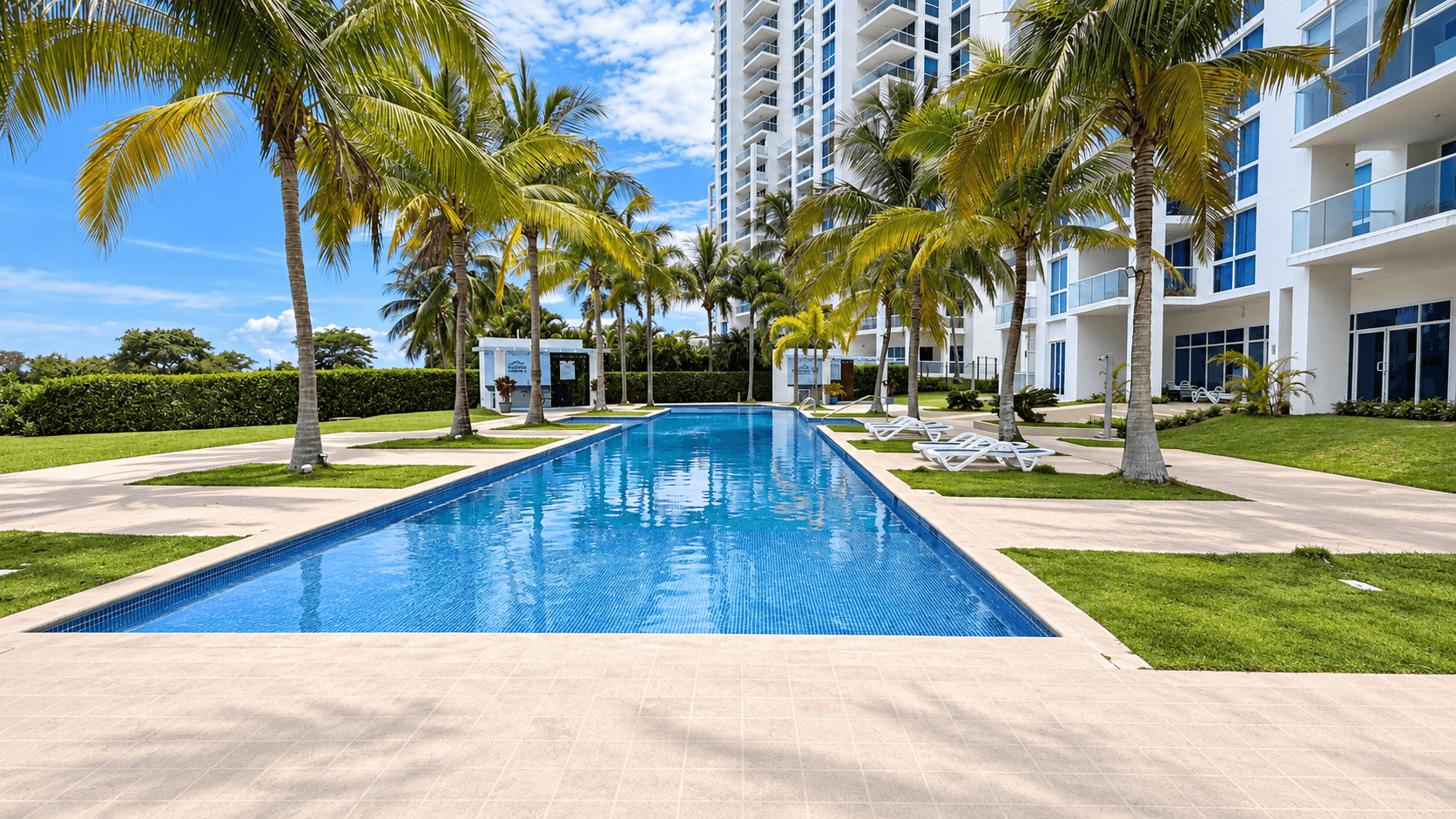 Piscina del complejo residencial rodeada de palmeras en Playa Blanca